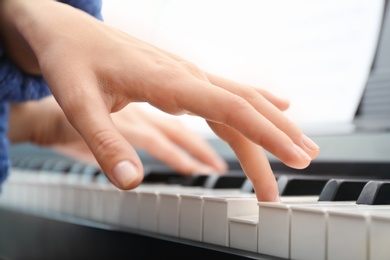 Woman playing piano, closeup view. Music lesson