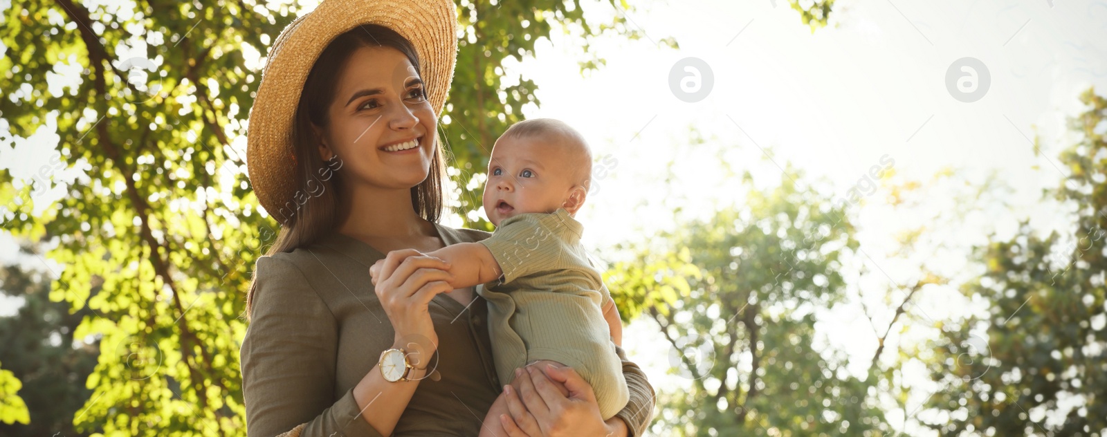 Image of Happy mother with cute baby in park on sunny day, space for text. Banner design 