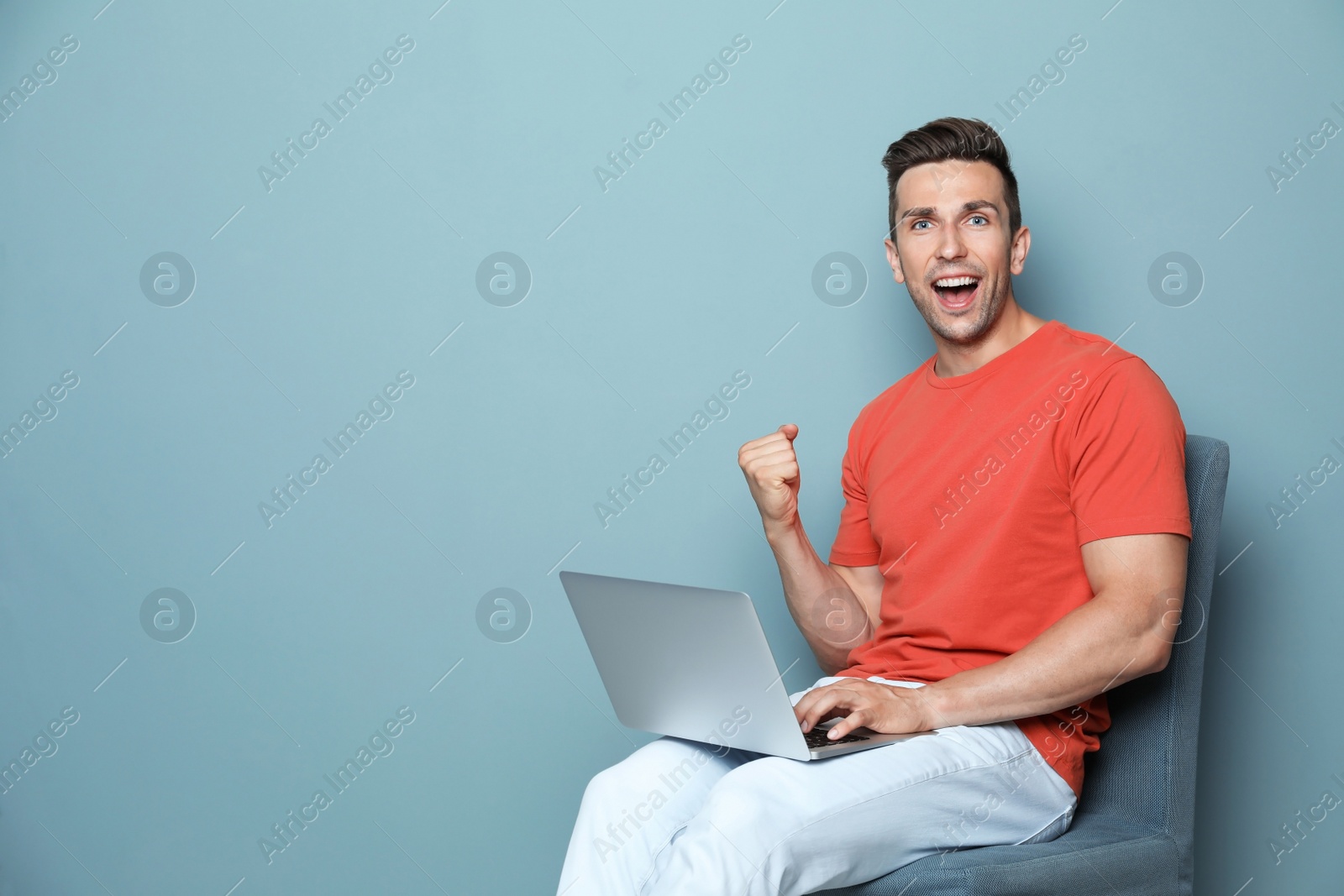 Photo of Man in casual clothes with laptop on color background