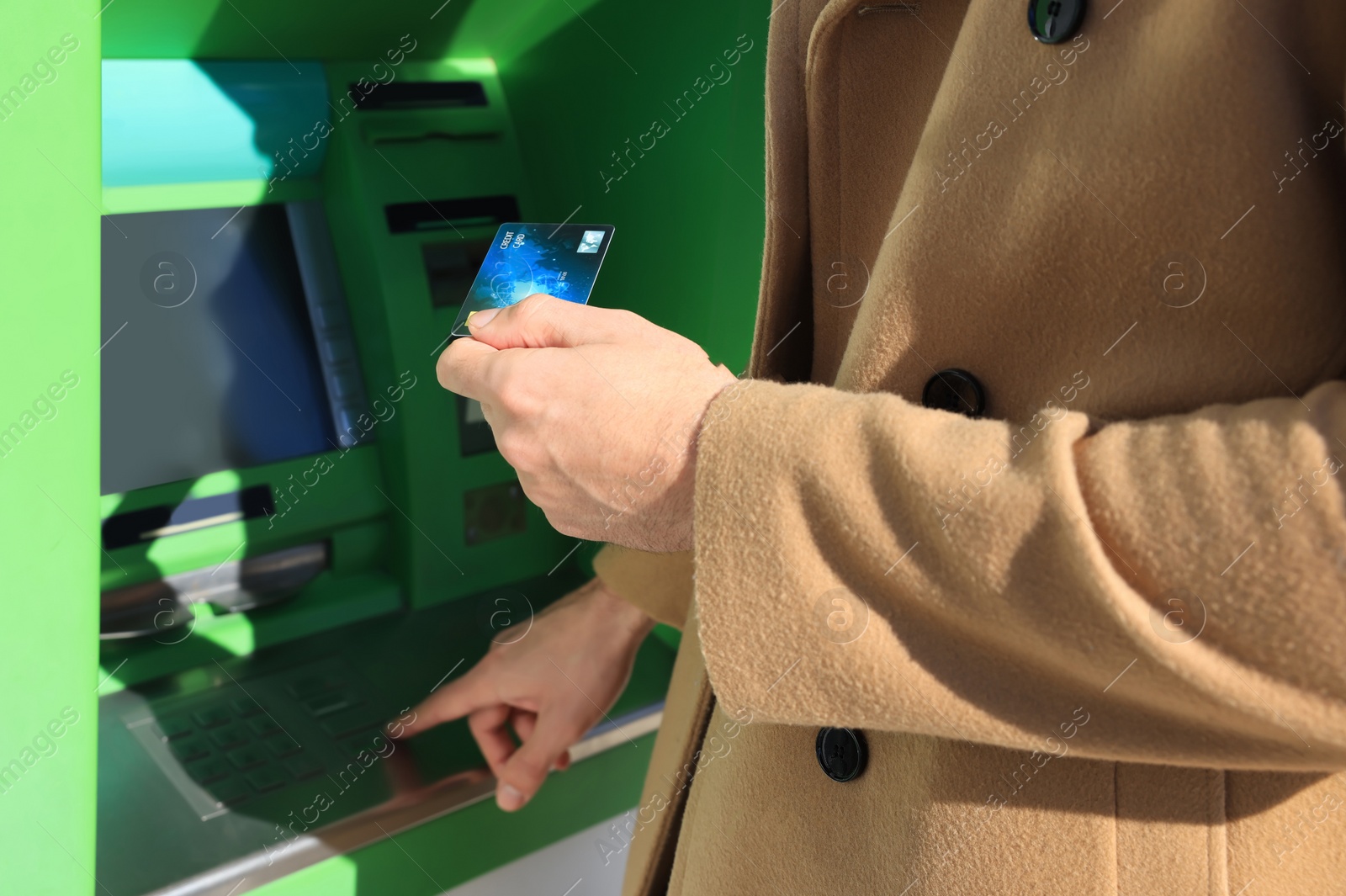 Photo of Man with debit card using modern cash machine, closeup of hand