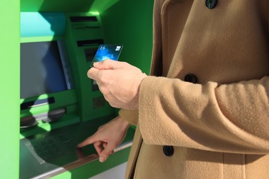 Photo of Man with debit card using modern cash machine, closeup of hand