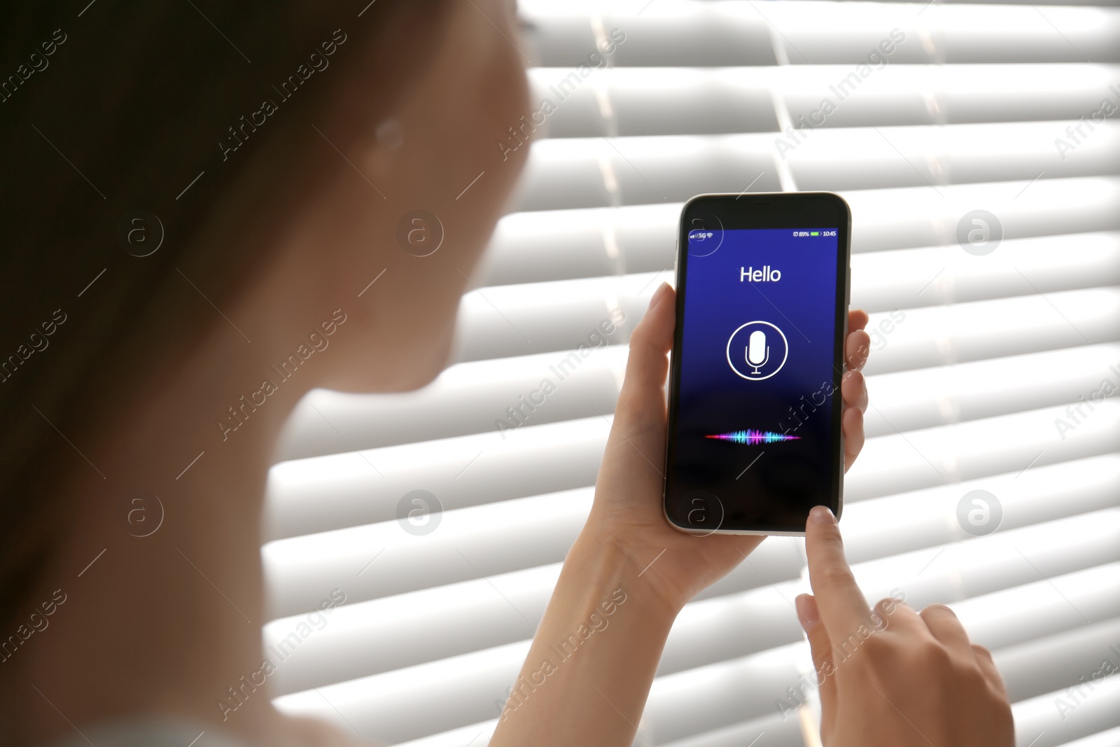 Photo of Woman using voice search on smartphone indoors, closeup
