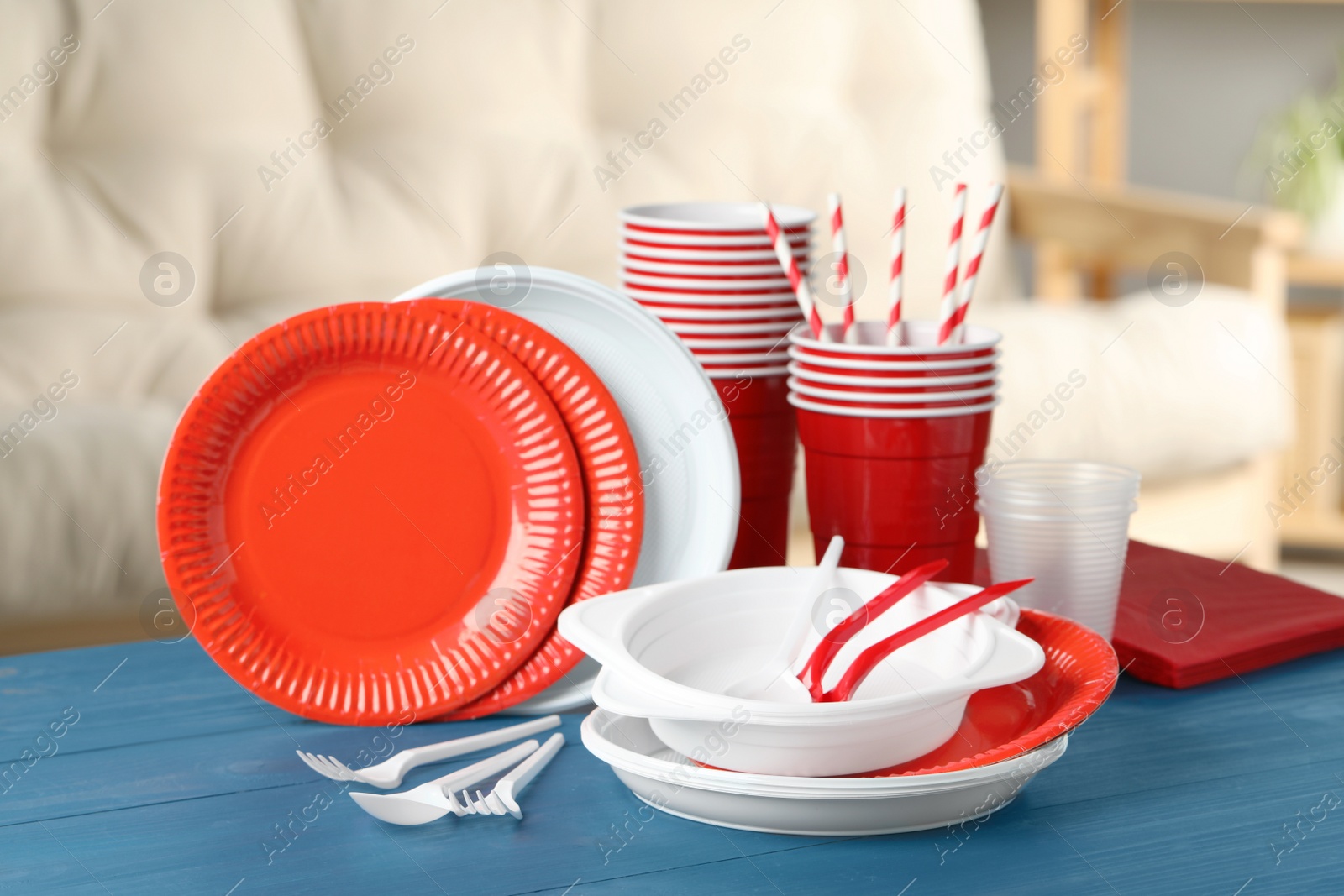 Photo of Disposable tableware on blue wooden table indoors