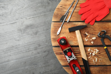 Different carpenter's tools on grey stone background, flat lay. Space for text