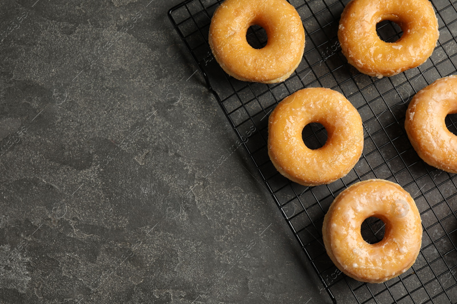 Photo of Delicious donuts on grey table, top view. Space for text