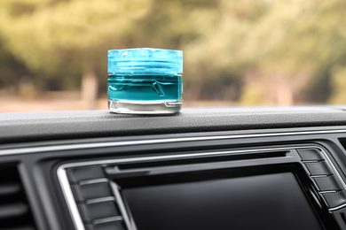 Photo of Stylish air freshener on dashboard in car