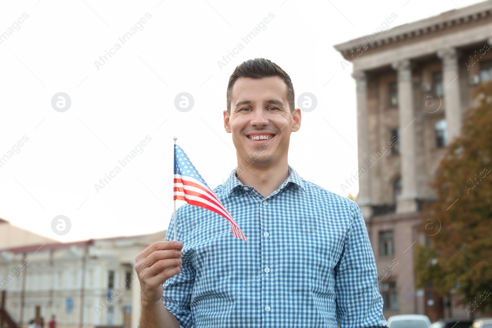 Photo of Man with American flag on city street