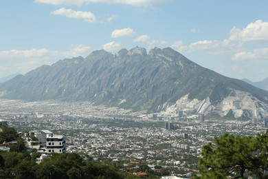 Photo of Picturesque view of city near high mountain under blue sky