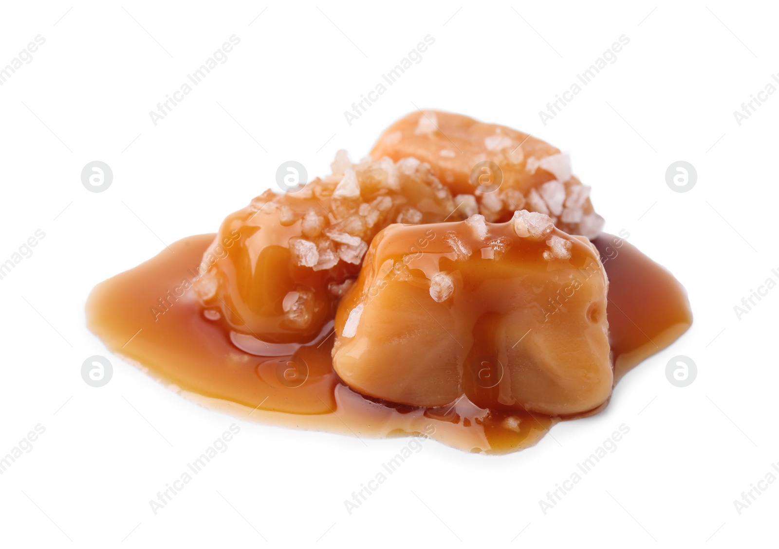 Photo of Yummy caramel candies and sea salt isolated on white