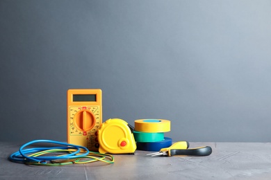Photo of Set of electrician's tools on table against gray background. Space for text