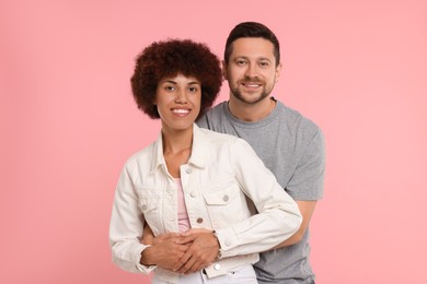 Photo of International dating. Happy couple hugging on pink background