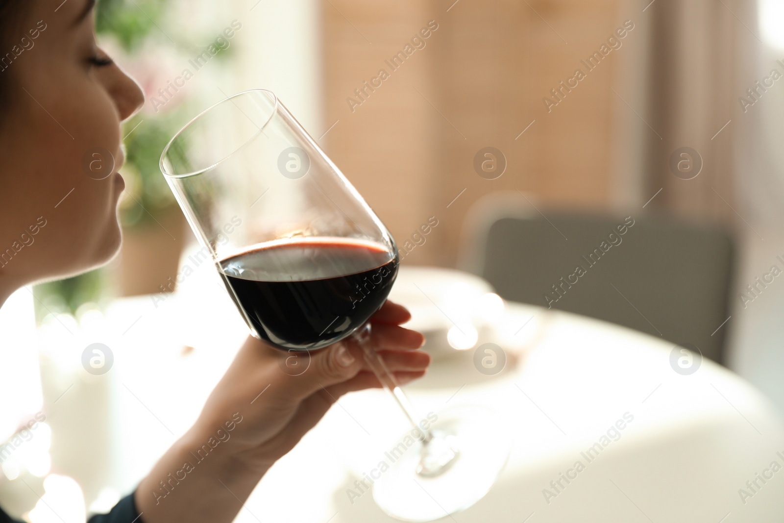 Photo of Woman with glass of wine in restaurant, closeup. Space for text