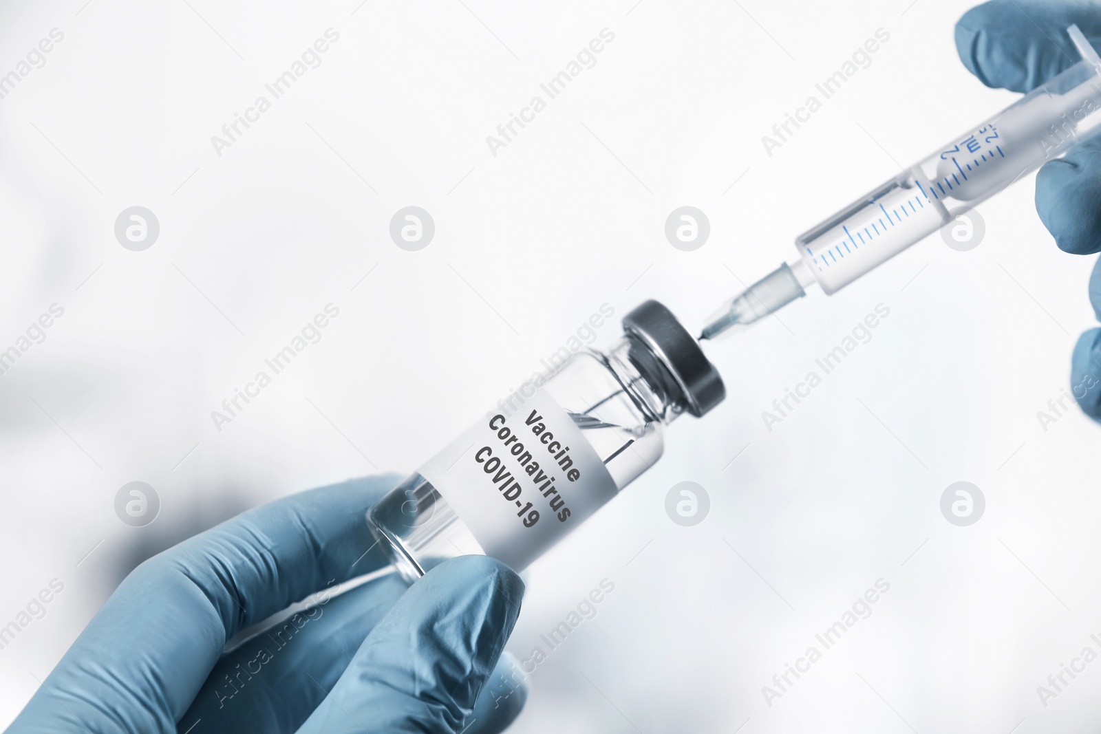 Image of Doctor filling syringe with coronavirus vaccine on white background, closeup