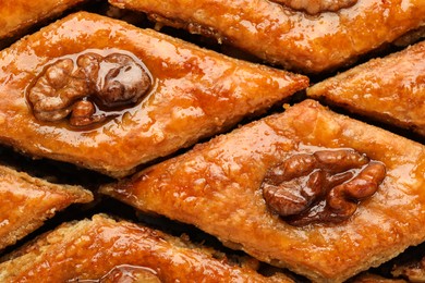 Delicious honey baklava with walnuts as background, top view