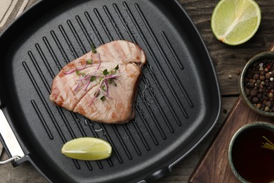 Photo of Delicious tuna steak served on wooden table, flat lay