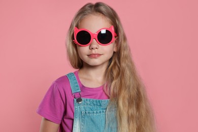 Girl in stylish sunglasses on pink background
