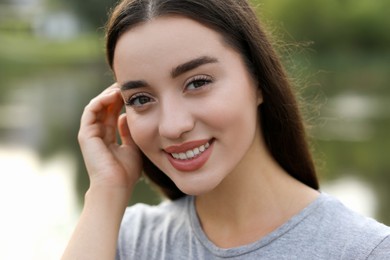 Photo of Portrait of beautiful woman outdoors. Attractive lady smiling and looking into camera