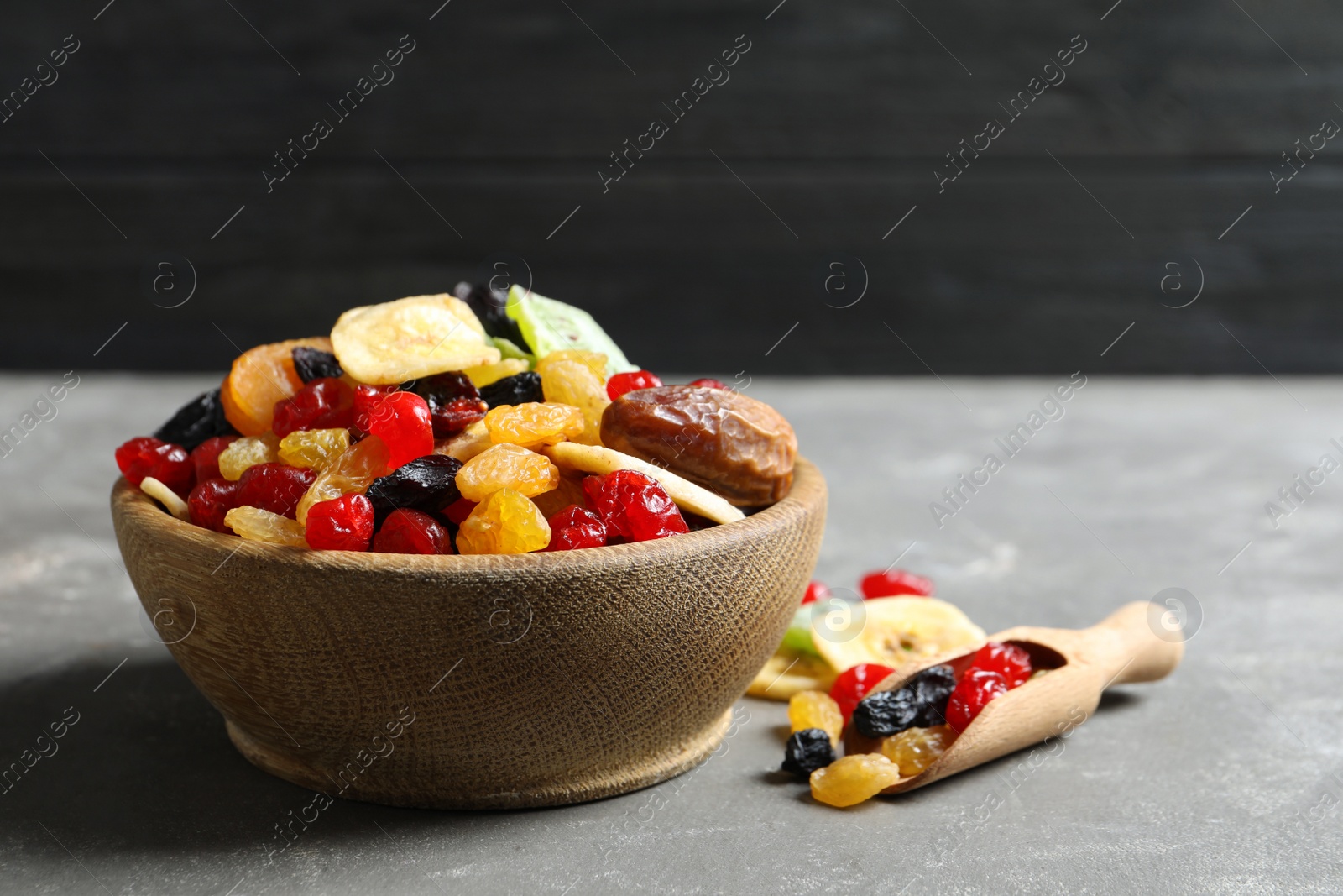 Photo of Bowl and scoop with different dried fruits on table, space for text. Healthy lifestyle