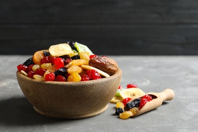 Bowl and scoop with different dried fruits on table, space for text. Healthy lifestyle
