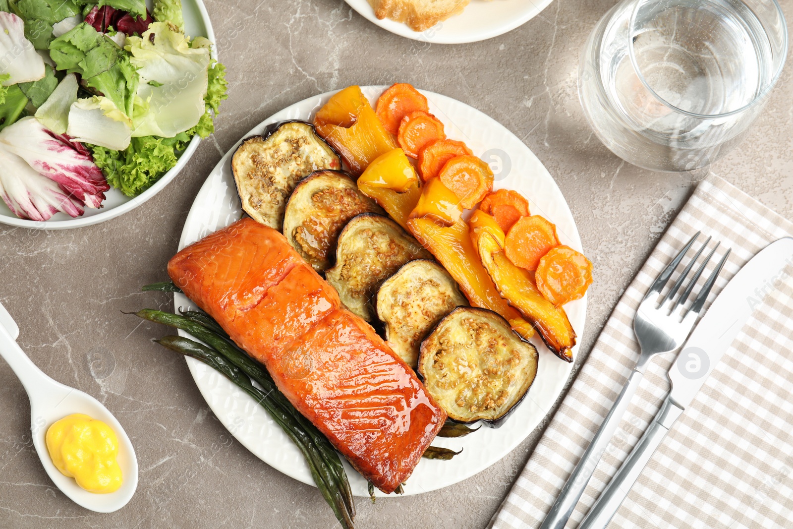 Photo of Delicious cooked salmon and vegetables served on grey table, flat lay. Healthy meals from air fryer