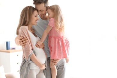 Young pregnant woman with her family at home