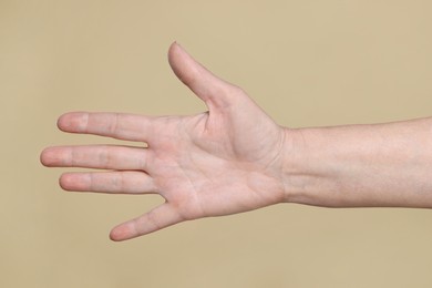 Photo of Closeup of woman's hand with aging skin on beige background. Rejuvenation treatment