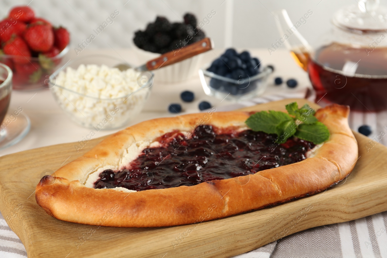 Photo of Delicious sweet cottage cheese pastry with cherry jam served on table, closeup