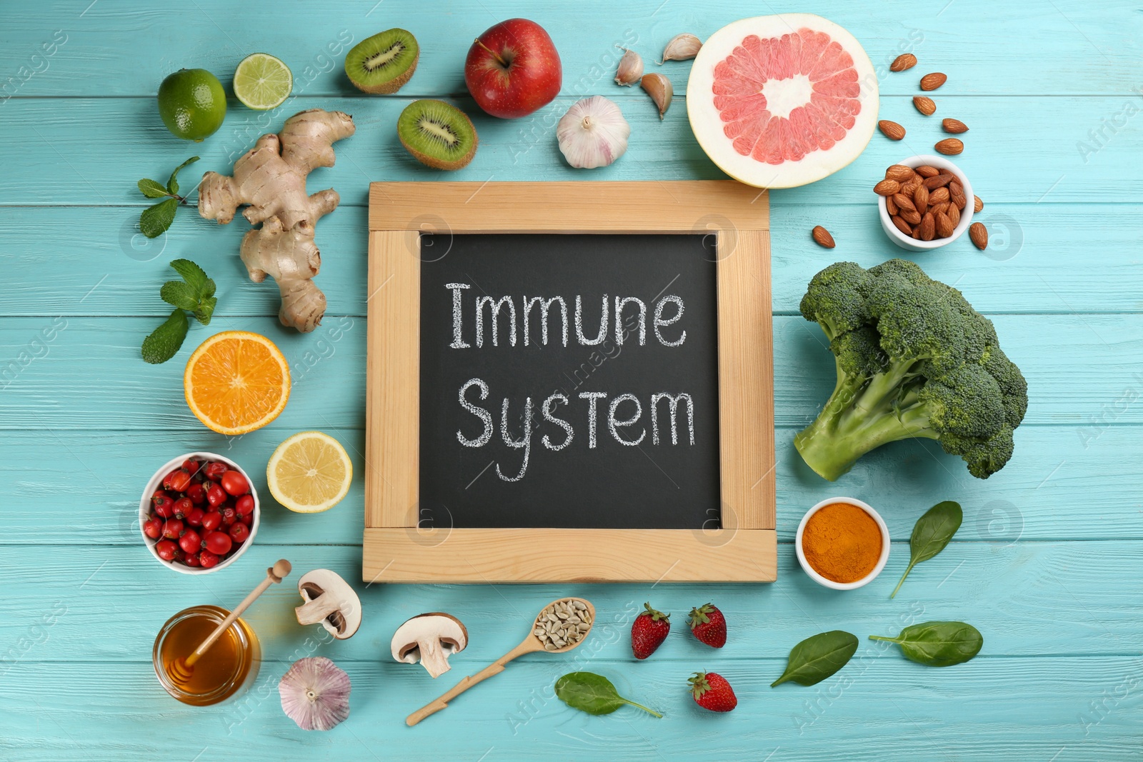 Photo of Chalkboard with phrase Immune System and fresh products on light blue wooden table, flat lay