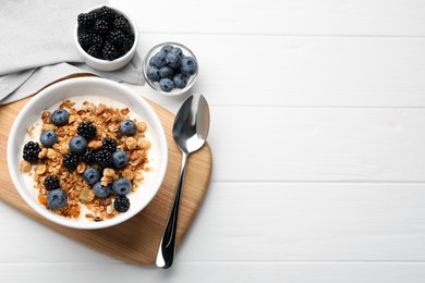 Photo of Bowl of healthy muesli served with berries on white wooden table, flat lay. Space for text