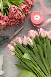 Photo of Beautiful pink tulips on grey table, flat lay