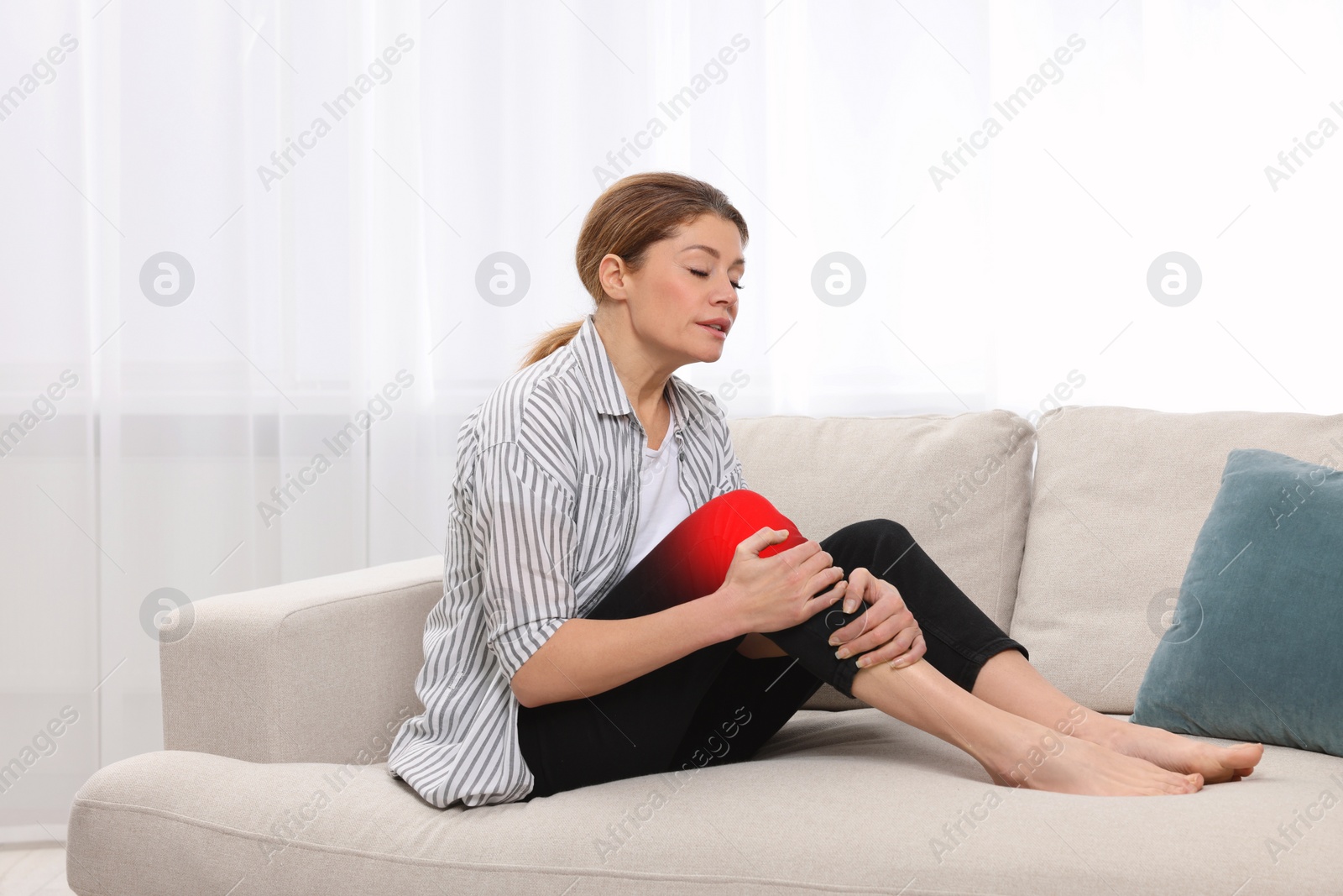 Image of Woman suffering from rheumatism in knee at home