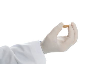 Photo of Doctor holding suppository for hemorrhoid treatment on white background, closeup