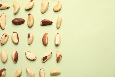 Photo of Flat lay composition with Brazil nuts and space for text on color background