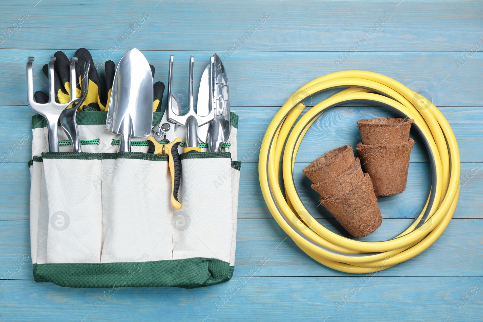 Photo of Flat lay composition with gardening tools on light blue wooden background