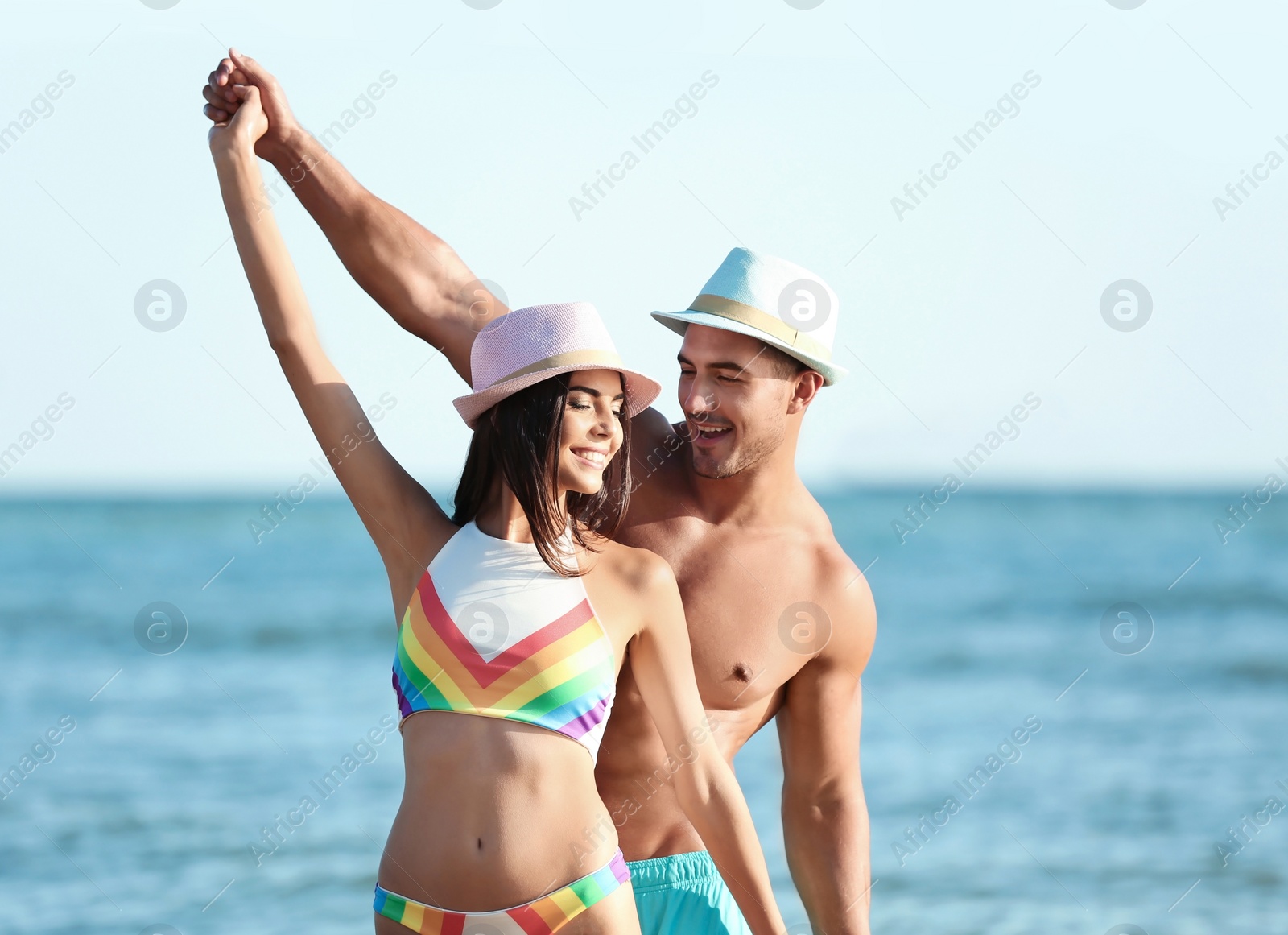 Photo of Happy young couple having fun at beach on sunny day