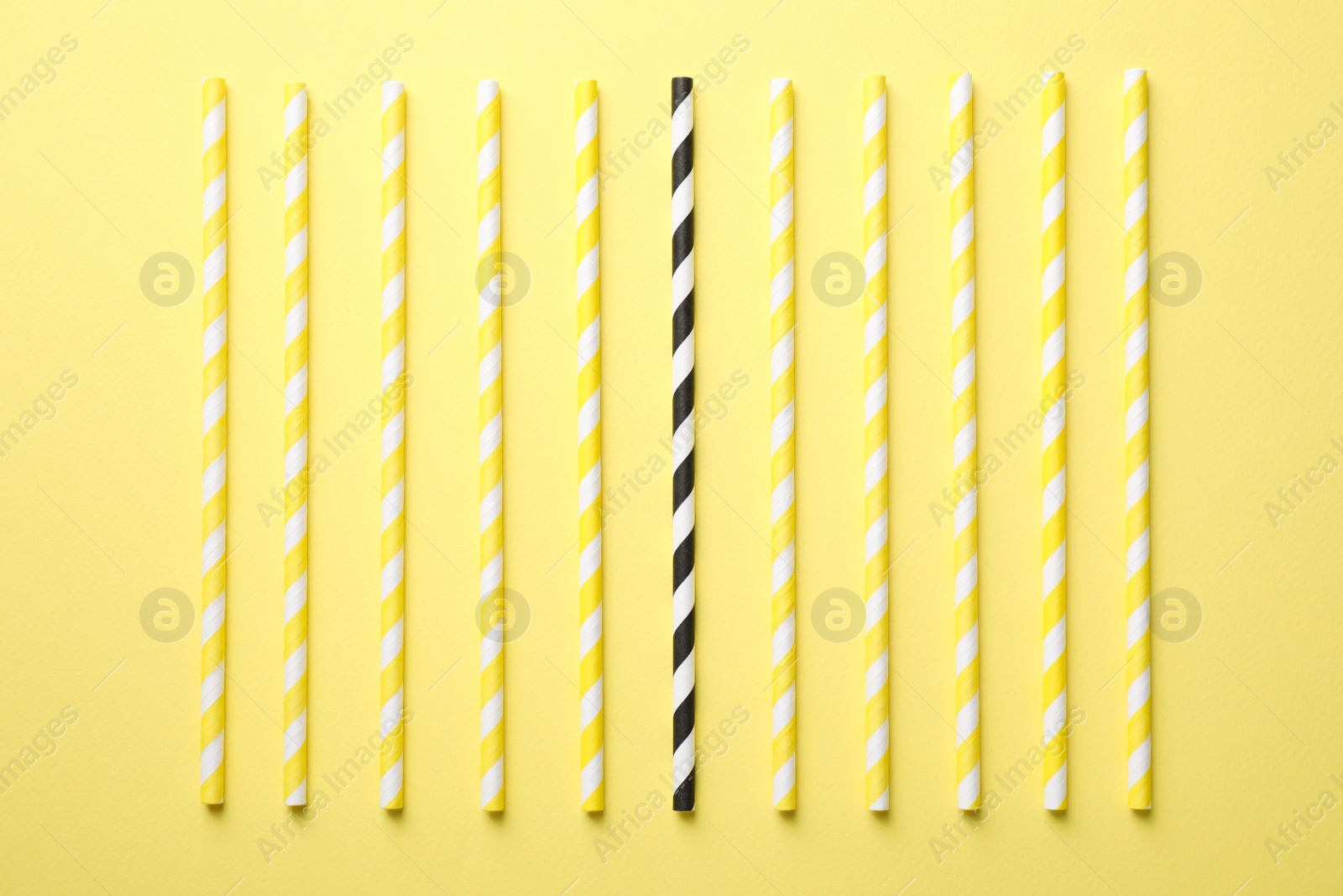 Photo of Collection of straws and different one on yellow background, flat lay