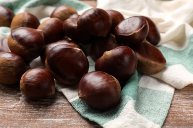 Sweet fresh edible chestnuts on wooden table, closeup