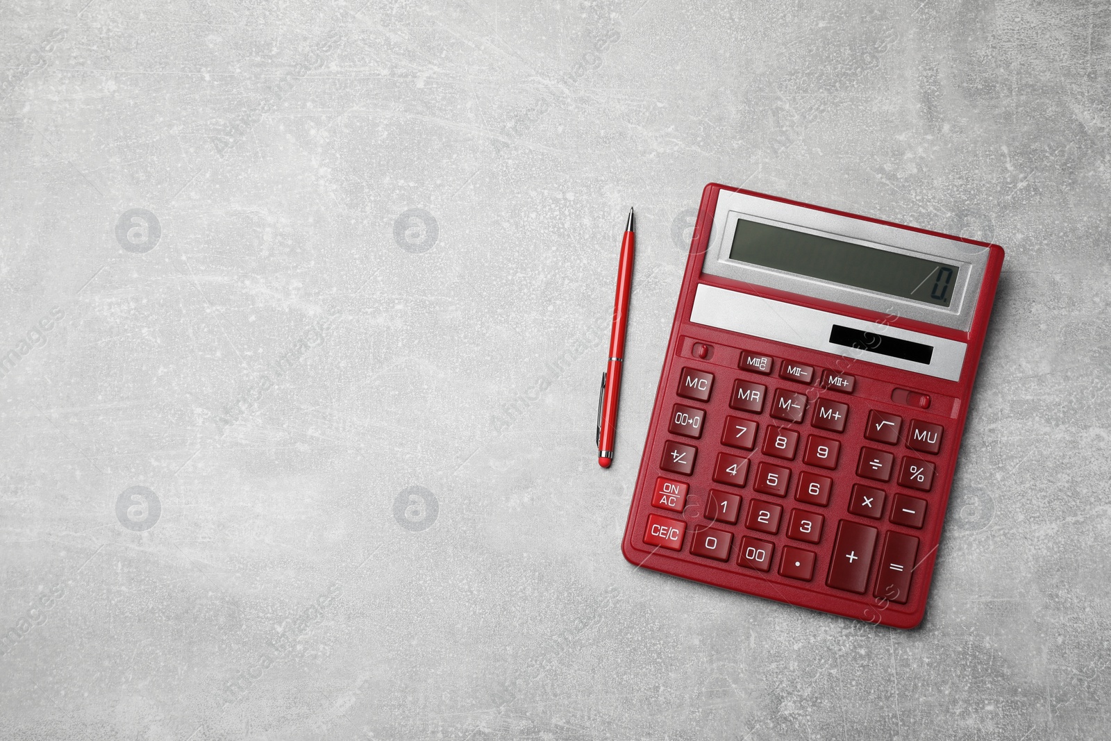 Photo of Calculator and pen on grey table, top view. Space for text