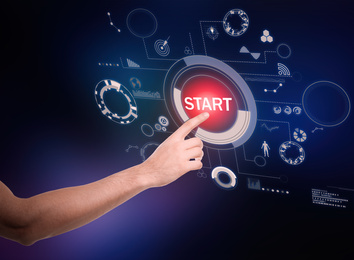 Image of Man pointing at start icon on dark background, closeup