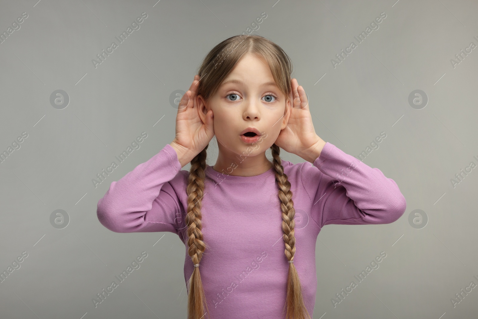 Photo of Little girl with hearing problem on grey background