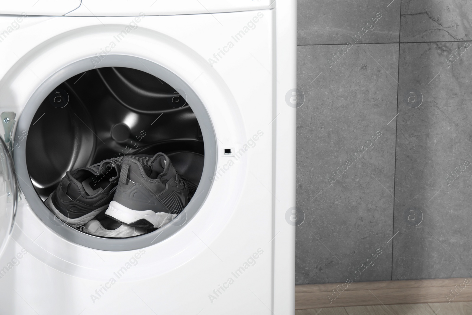 Photo of Stylish clean sneakers inside modern washing machine