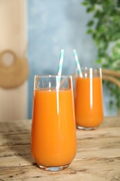 Photo of Freshly made carrot juice on wooden table