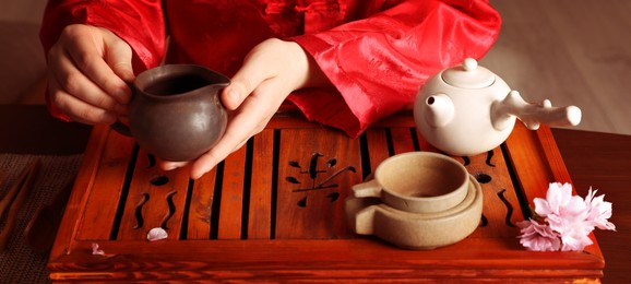Image of Master conducting traditional tea ceremony at table indoors, closeup. Banner design