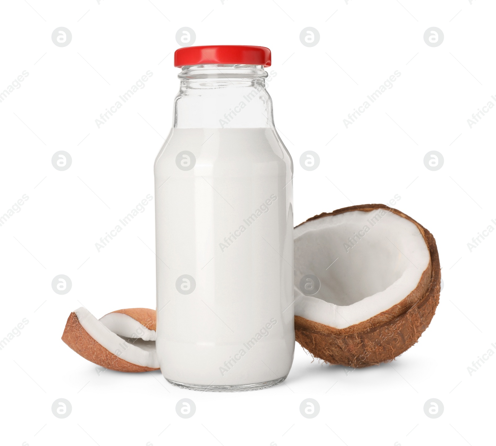 Photo of Glass bottle of delicious vegan milk and coconut pieces on white background