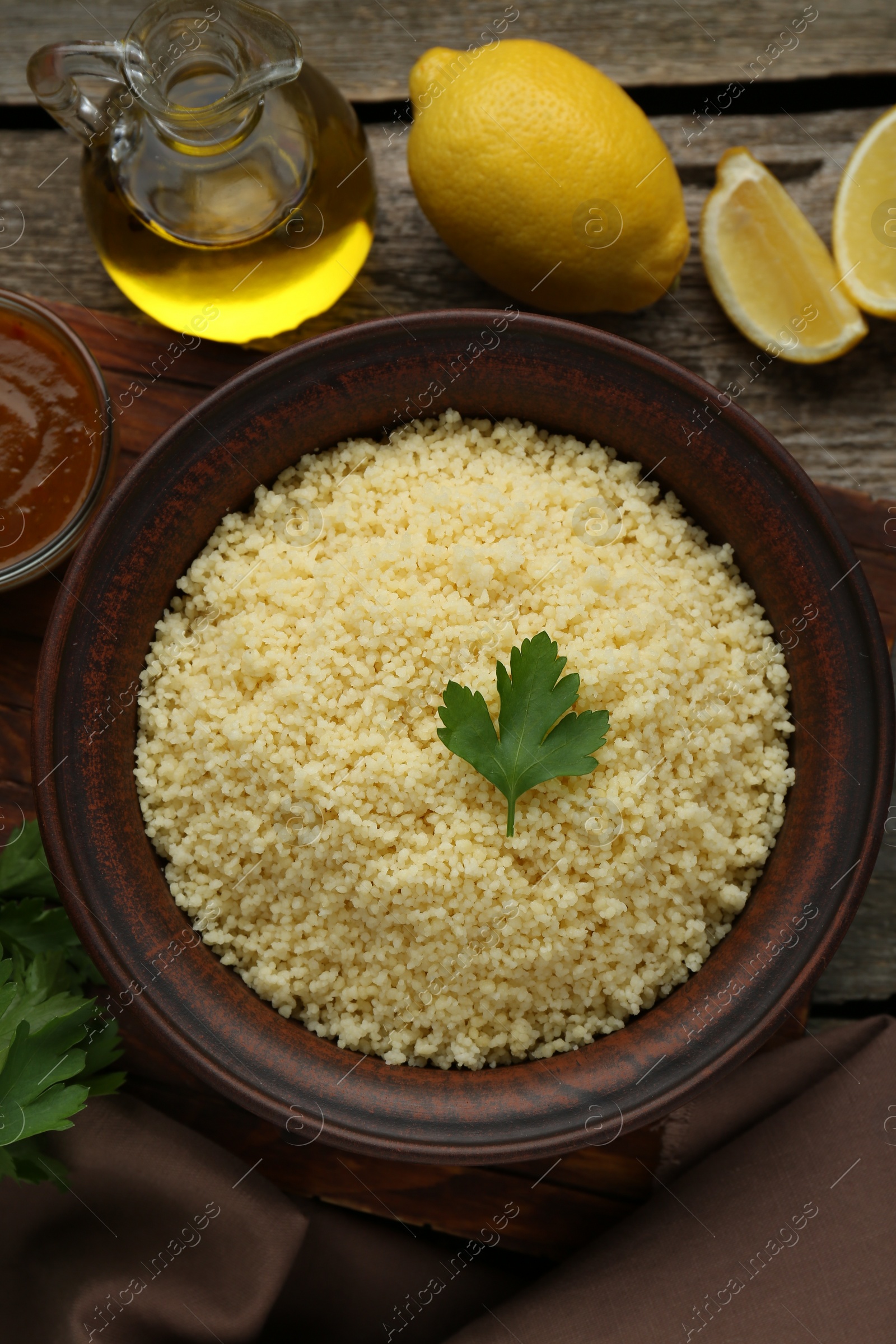 Photo of Tasty couscous and ingredients on wooden table, flat lay