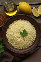 Photo of Tasty couscous and ingredients on wooden table, flat lay