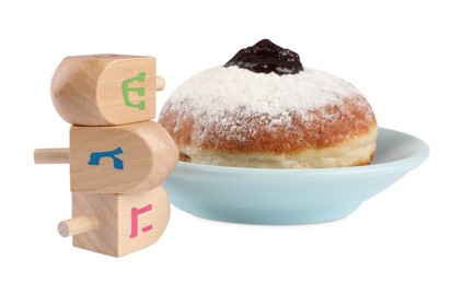 Photo of Hanukkah celebration. Wooden dreidels with jewish letters and donut isolated on white