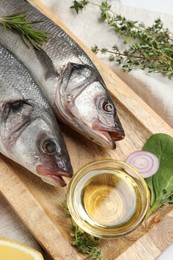 Photo of Tasty sea bass fish and ingredients on white table