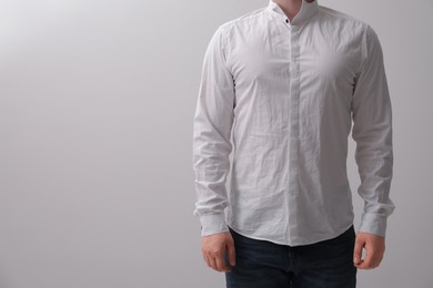 Photo of Man wearing rumpled shirt on white background, closeup
