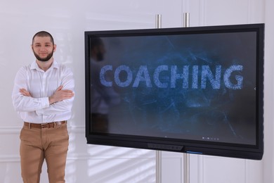 Photo of Business trainer near interactive board in meeting room